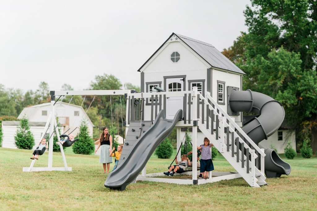 A large gray and white playhouse swing set