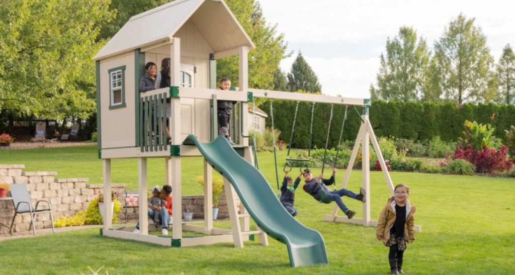 kids swinging and playing on tan and green space station series playhouse swing set