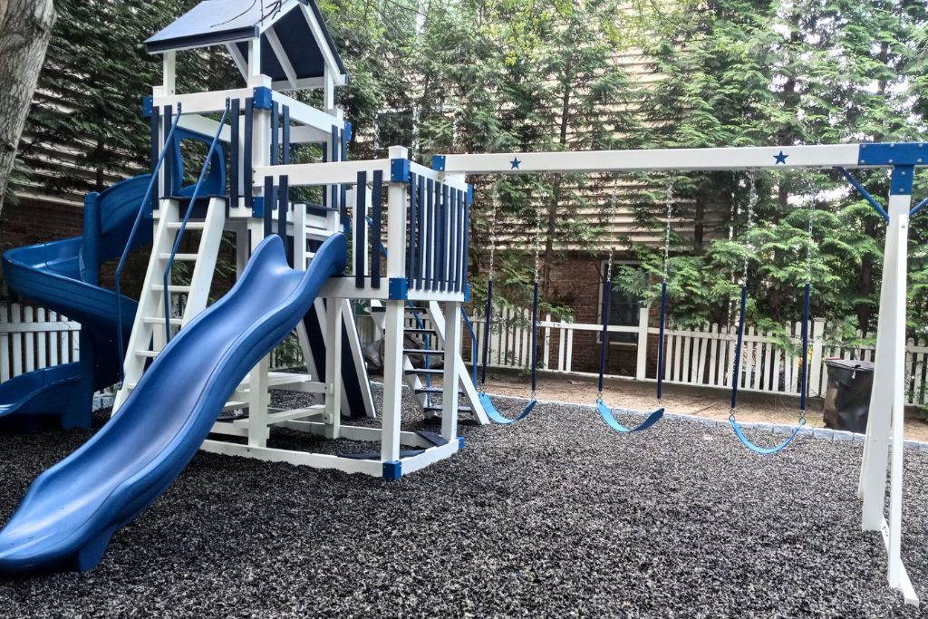 Black rubber mulch with blue and white swingset